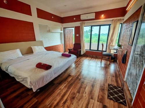 a bedroom with a large bed and wooden floors at Abaca AuroVibe in Kuilapayam