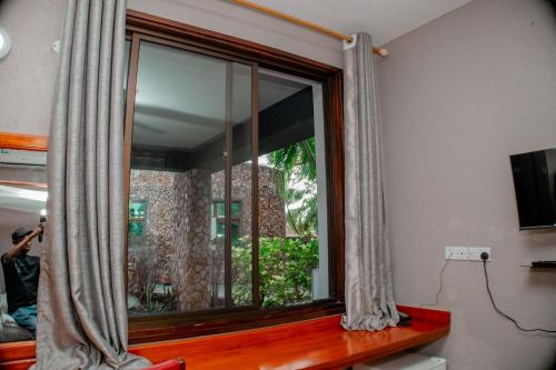 a window in a room with a person taking a picture at Hotel & Apartment Serene in Dar es Salaam
