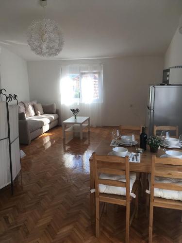 ein Wohnzimmer mit einem Tisch und einem Kühlschrank in der Unterkunft Centre Apartment Bozava in Božava