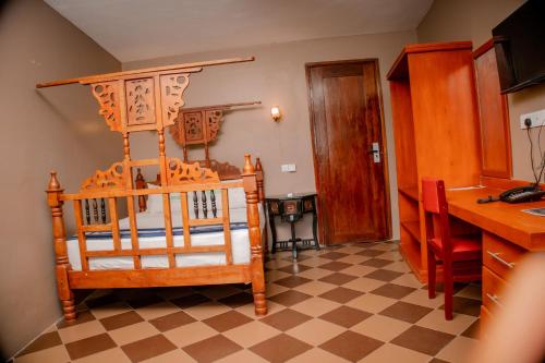 a bedroom with a wooden bed with a checkered floor at Hotel & Apartment Serene in Dar es Salaam