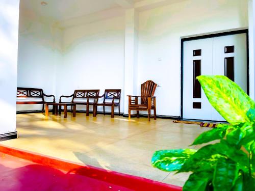 a room with chairs and a table with a plant at Sigiri Pandora Lodge & Hostel in Sigiriya