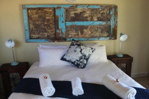a bedroom with a bed with two pairs of socks on it at Shamba Yetu Mountain Lodge in Maanhaarrand