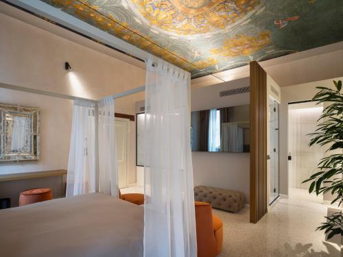 a bedroom with a bed with a painted ceiling at Palazzetto MyVenice in Venice