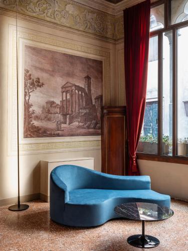 a living room with a blue couch and a painting at Palazzetto MyVenice in Venice