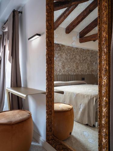 a large mirror in a bedroom with a bed at Palazzetto MyVenice in Venice