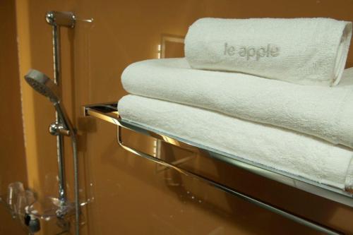 a pile of towels on a rack in a bathroom at Le Apple Boutique Hotel Bukit Bintang in Kuala Lumpur