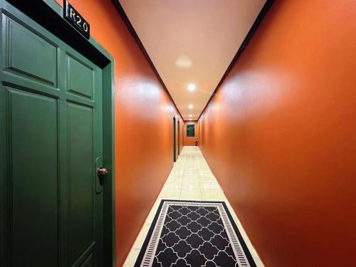 a hallway with a green door and a carpet at Little Friendly Guest House with pool in Luang Prabang