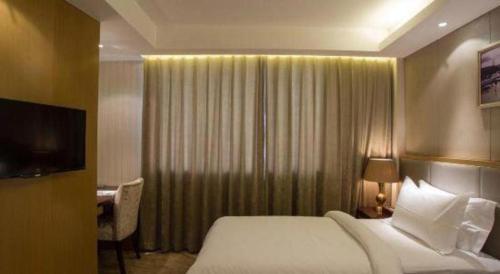 a hotel room with a bed and a television at Jinjiang Metropolo Shanghai Minhang in Shanghai
