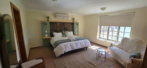 a bedroom with a bed and a couch at Safari Park Guest Farm in Colesberg
