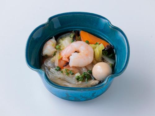 a small blue bowl filled with soup with shrimp and vegetables at One Station Hotel Kumamoto -DLIGHT LIFE & HOTELS- in Kumamoto