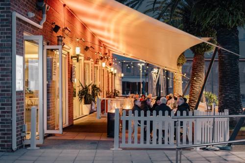 a group of people sitting at a table outside a restaurant at Rydges Newcastle in Newcastle