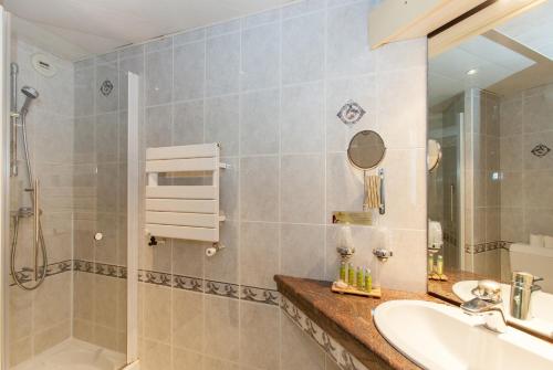 a bathroom with a sink and a shower at Cit'Hotel le Challonge in Dinan