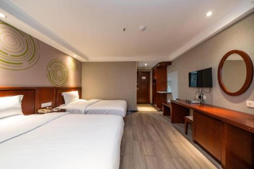 a hotel room with two beds and a mirror at GreenTree Inn Nanning Langdong Hotel in Nanning