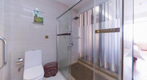 a bathroom with a glass shower and a toilet at Shenzhen Kai Long International Hotel in Shenzhen