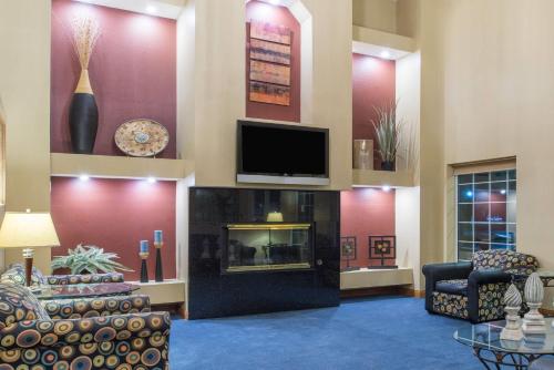 a lobby with a fireplace and a flat screen tv at Ramada by Wyndham Springfield North in Springfield