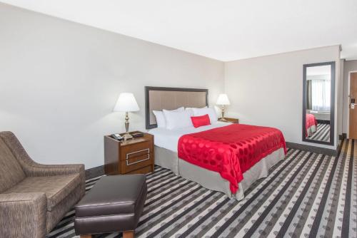 a hotel room with a bed and a couch at Ramada by Wyndham Springfield North in Springfield
