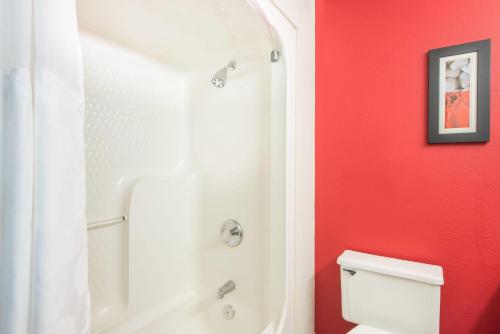 a bathroom with a shower and a white toilet at Ramada by Wyndham Springfield North in Springfield