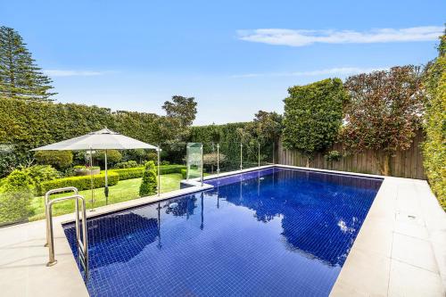 シドニーにあるKINGS10V - Luxe at Kingsの傘付きの庭のスイミングプール