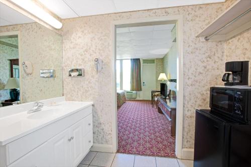 a bathroom with a sink and a mirror at Days Inn by Wyndham Parsippany in Parsippany
