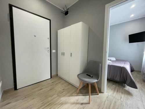 a room with a chair and a bed and a mirror at Hierá Guest House in Milazzo