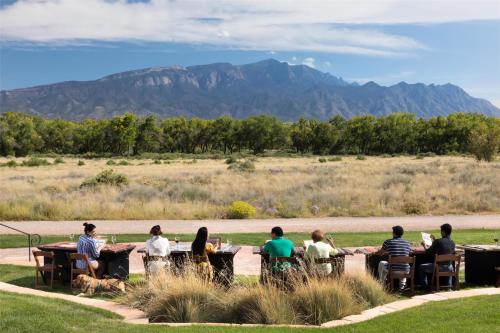 a group of people sitting at a table with mountains in the background at Hyatt Regency Tamaya South Santa Fe in Santa Ana Pueblo