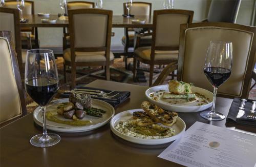 a table with three plates of food and two glasses of wine at Hyatt Regency Tamaya South Santa Fe in Santa Ana Pueblo