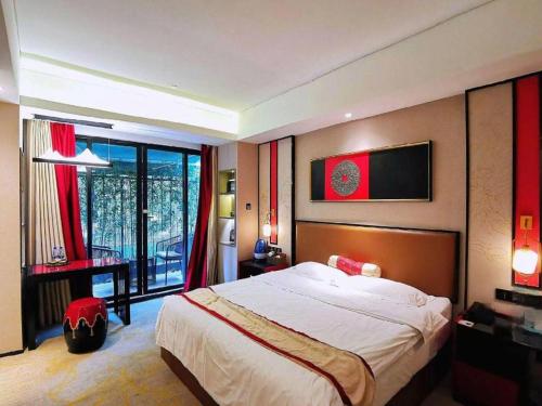 a bedroom with a large bed and a large window at Yuan Culture Hotel Shenzhen World Shajing in Shenzhen
