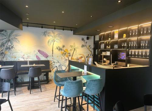 a restaurant with a bar with chairs and tables at Best Western Hotel Breitbach in Ratingen