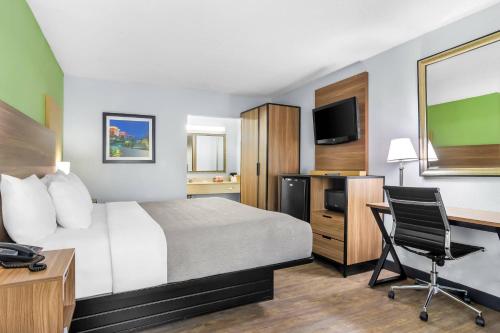 a hotel room with a bed and a desk and a computer at Quality Inn & Suites Greenville - Haywood Mall in Greenville