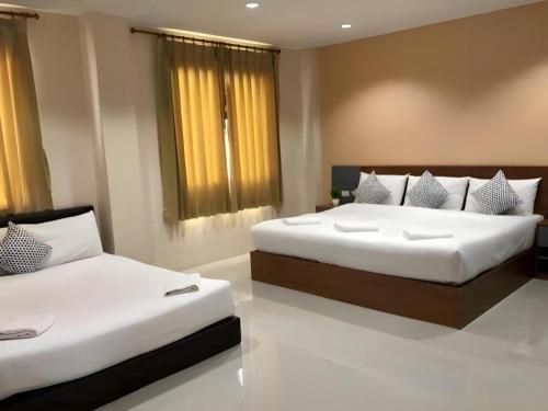 two beds in a room with two beds sidx sidx sidx sidx at Regent Room Hotel in Suratthani