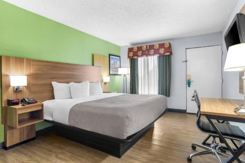 a hotel room with a large bed and a desk at Quality Inn & Suites Greenville - Haywood Mall in Greenville