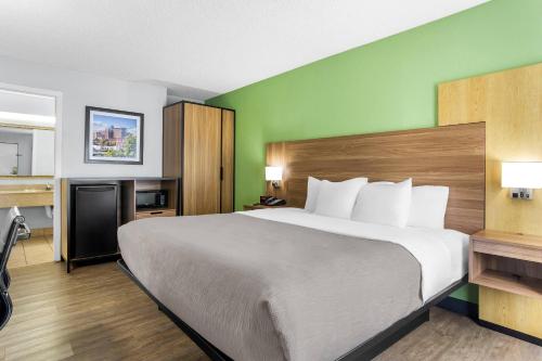a bedroom with a large bed and a green wall at Quality Inn & Suites Greenville - Haywood Mall in Greenville