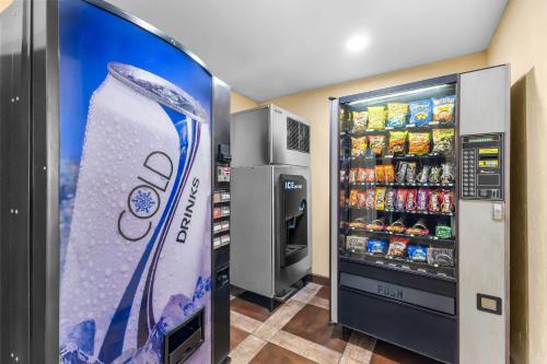 a soda vending machine in a room with a refrigerator at Quality Inn & Suites Salt Lake City Airport West in Salt Lake City