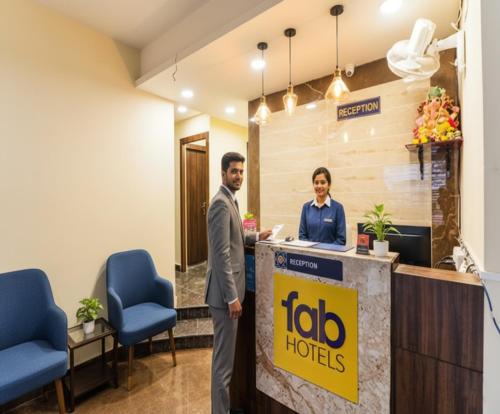 a man and a woman standing at a hotel reception desk at FabHotel Carnival in Kolkata