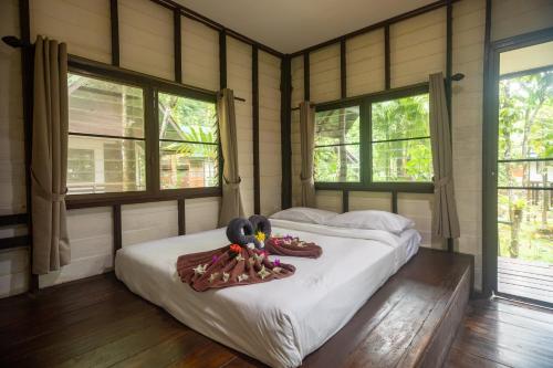 a bedroom with a bed with shoes on it at The Vatika Resort and Spa in Ao Nang Beach