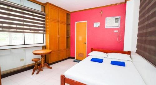 a bedroom with a bed and a red wall at Mayon Backpackers Hostel in Legazpi