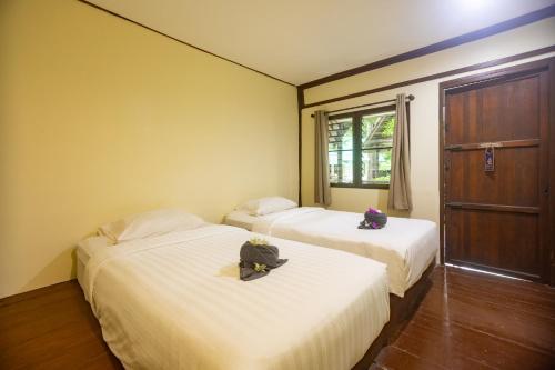 two beds in a room with two bags on them at The Vatika Resort and Spa in Ao Nang Beach