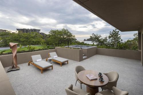 a balcony with chairs and a table and chairs at Waldorf Astoria Costa Rica Punta Cacique in Playa Hermosa