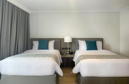 two beds sitting next to each other in a room at La Quinta by Wyndham Quito in Quito