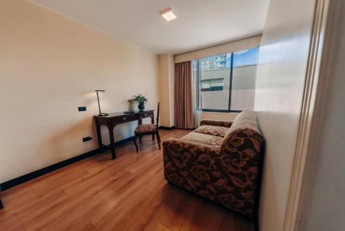 a living room with a chair and a desk at La Quinta by Wyndham Quito in Quito
