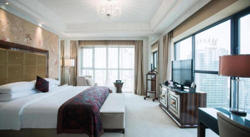 a hotel room with a large bed and a television at Fortune International Hotel in Xiawutun