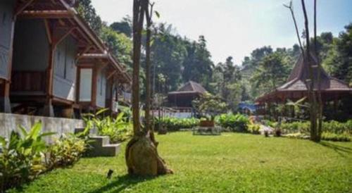 a yard with a house and a tree stump at VillaTel Salse in Bandung