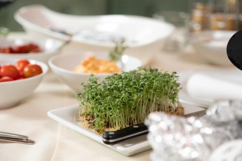 a table topped with a plate of food with vegetables at Gasthof Neuwirt in Eugendorf