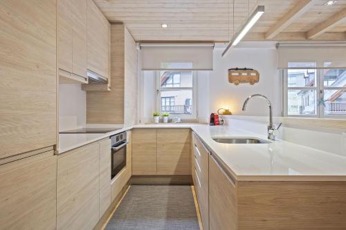 une cuisine avec des armoires en bois et un évier dans l'établissement Luderna - Apartamento Val de Ruda A30 Manaud, à Baqueira-Beret