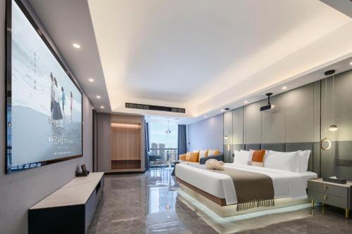 a bedroom with a large bed and a flat screen tv at Dori1993 Hotel in Changsha