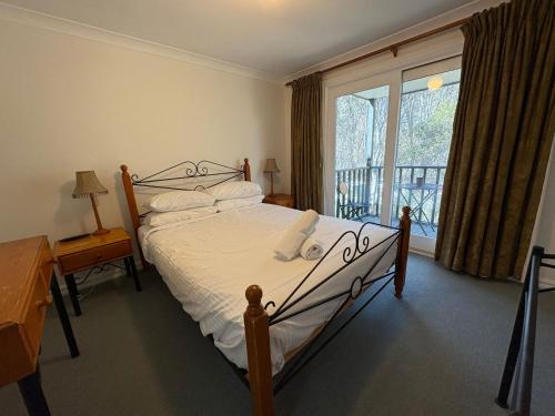 a bedroom with a bed and a large window at Three Bears 2 - Thredbo in Thredbo