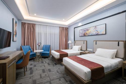 a hotel room with two beds and a desk at Sunlight Hotel Puerto Princesa in Puerto Princesa City