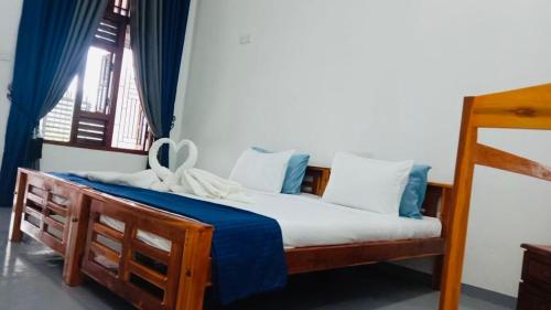 a bedroom with a bed with blue and white pillows at Coastal Heaven in Pottuvil