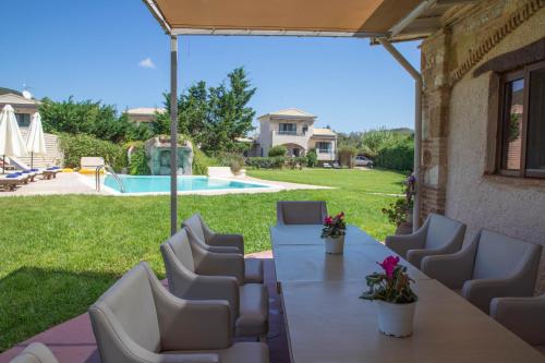 a patio with a table and chairs and a pool at Stalakton Country Maisonettes in Halikounas