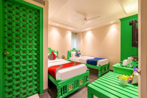 two beds in a room with green and white at The Pinky Villa - Heritage Boutique Suites- New Delhi in New Delhi